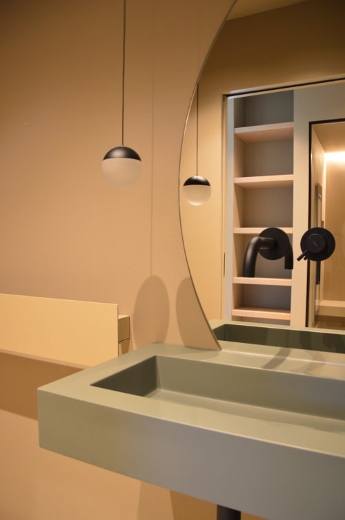 Lavabo moderno a Villa Rosati con luci a sospensione, specchio, ripiani e dettagli neri a Sanzeno