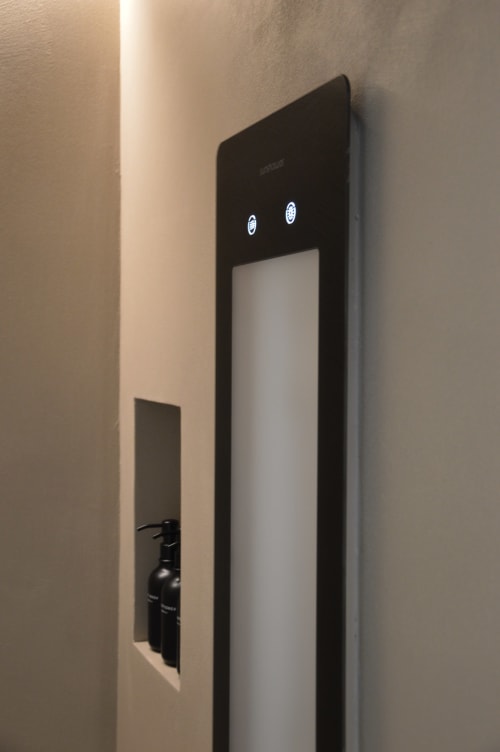 Moderno dispenser d'acqua nero con due pulsanti montato su parete beige nella camera Villa Rosati