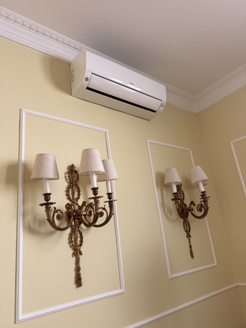 Elegantes apliques de pared con pantallas color crema y herrajes bronce ornamentado en Edificio San Esteban 16, Sevilla