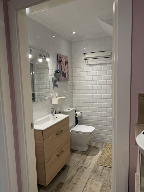 Baño moderno en la casa rural CaleaCabo, Asturias, con azulejos blancos metro, mueble de madera, inodoro y ducha