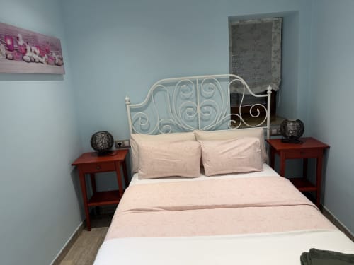 Acogedora habitación en el hotel rural CaleaCabo de Asturias con cama ornamental, mesillas rojas y vistas a la montaña