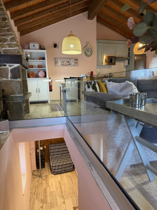 Habitación de estilo loft moderno en casa rural asturiana con cocina, comedor, vigas vistas y vistas a las montañas