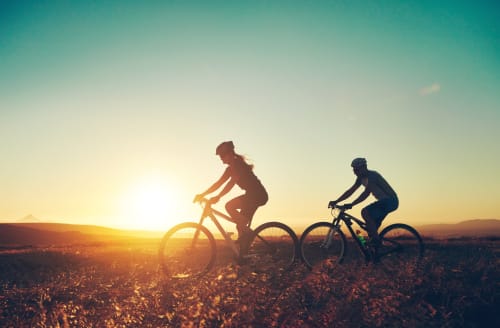 Due ciclisti in bicicletta al tramonto vicino a Ceva, Italia, simbolo di avventura all'aperto presso Residenza Basiglio