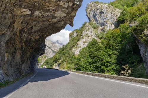 Strada di montagna attraverso una gola calcarea vicino a Ceva, Italia con tunnel e picchi rocciosi