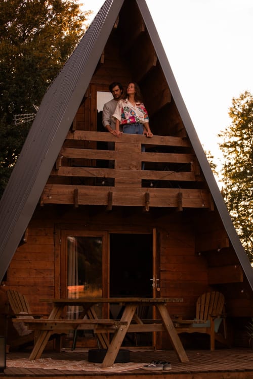 Couple à la cabane en A de Mesnil & Une Nuit à Gisay la Coudre, France, avec vue sur la forêt et terrasse