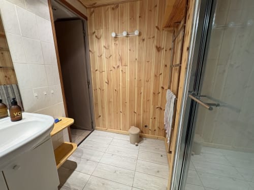 Salle de bain moderne avec lambris bois et douche vitrée à l'Appartement 308B du GNM Varsea, Vars
