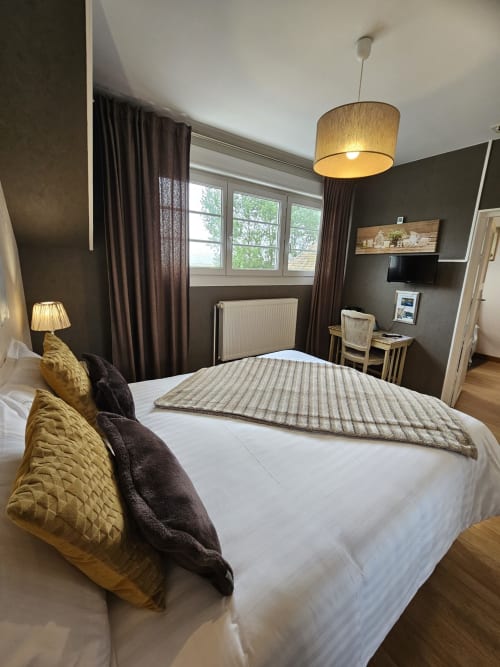 Chambre moderne aux Portes du Hable à Cayeux-sur-Mer : lit queen-size, vue sur jardin et mobilier élégant.