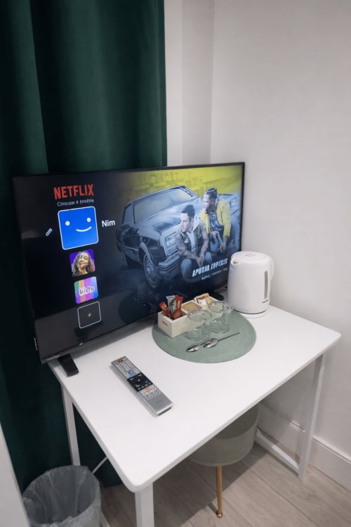 Netflix streaming setup on desk in La Rose Serenity Residence London bedroom with remote and white kettle