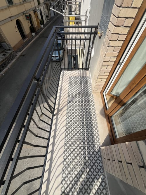 Balcone stretto con pavimento decorato presso Marelia Suites a Italia, con ringhiera nera e vista città