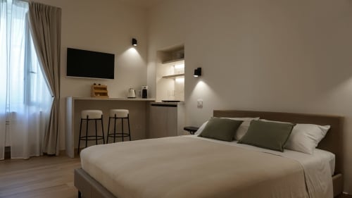 Monolocale moderno presso Marelia Suites in Italia con letto, angolo cottura, TV e vista sulla città