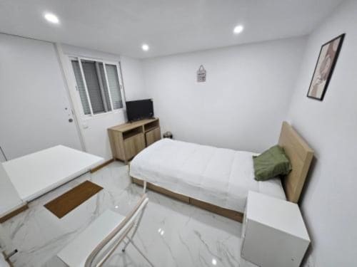 Quarto moderno no Hotel Boeing AL em Moreirada Maia com cama, TV e mobiliário minimalista