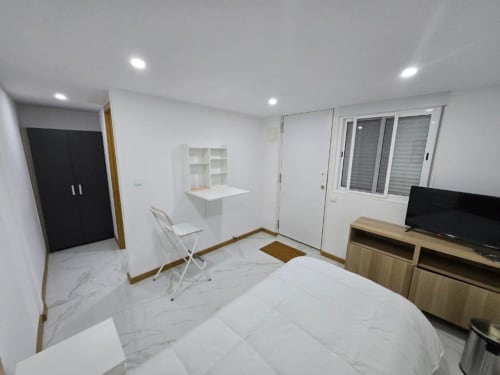Quarto moderno no hotel Boeing AL em Moreirada Maia com piso de mármore, TV, escrivaninha e móveis contemporâneos