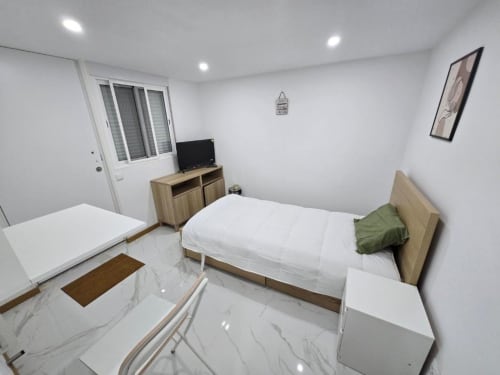 Quarto moderno do hotel Boeing AL em Moreirada Maia com cama, TV, móveis em madeira e piso em mármore