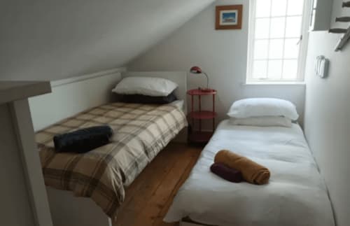 Twin bedroom in Clara Place cottage at 2 Doves Holiday Property, Exeter, with white pillows and brown bedding