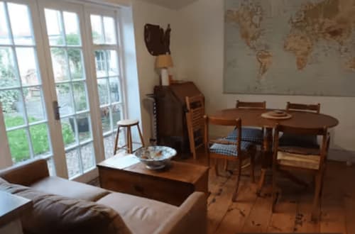 Clara Place cottage dining and sitting area with wooden furniture, garden view windows, and world map at 2 Doves Holiday