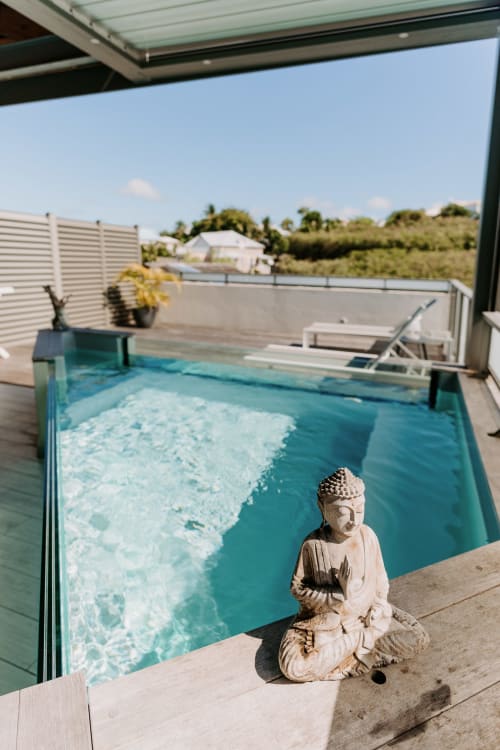 Buddha statue beside private turquoise pool at Habitation l'SEO, Sainte-Anne Guadeloupe