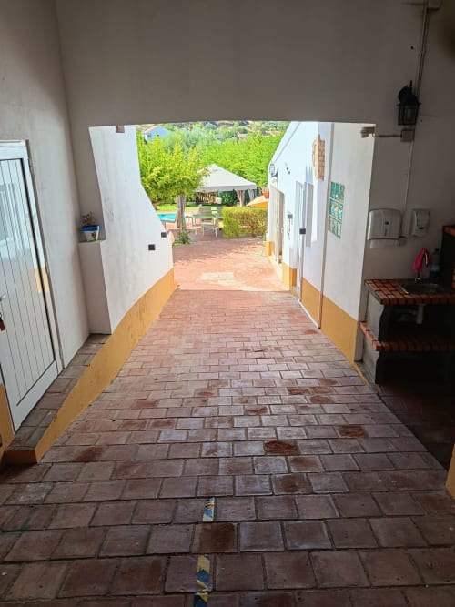 Corredor coberto na Pousada Cerro da Janela em Alte que leva à piscina e ao pátio do jardim