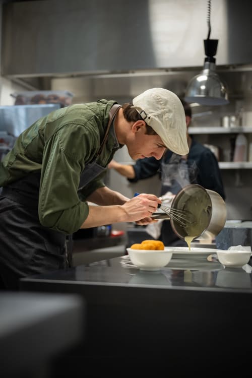 Chef preparing food in kitchen at B&B Sens'UP near Pairi Daiza, Brugelette