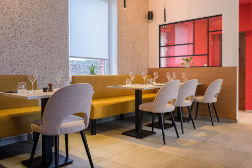 Modern restaurant dining area with yellow banquette seating and gray chairs at B&B Sens'UP near Pairi Daiza, Brugelette