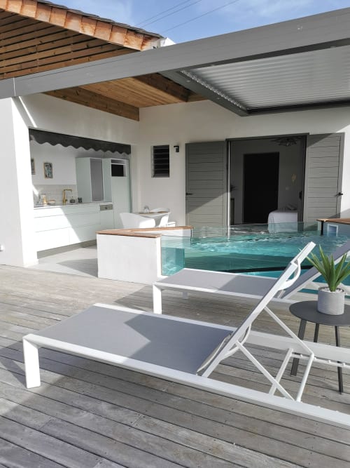 Patio de l'appartement Le Voyageur avec transats, piscine privée turquoise, kitchenette et pergola à Habitation l'SÉO