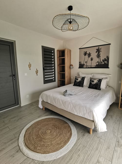 Chambre moderne à l'Habitation I'SEO à Sainte-Anne avec lit queen-size, art mural tropical, tapis tissé et équipements contemporains