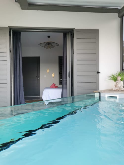 Appartement Le Voyageur à Habitation I'SEO avec piscine privée turquoise ouvrant sur la chambre, Sainte-Anne
