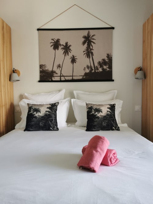 Chambre moderne à l'Habitation l'SEO à Sainte-Anne avec décoration murale palmiers, literie blanche, coussins noirs à motifs et accents roses