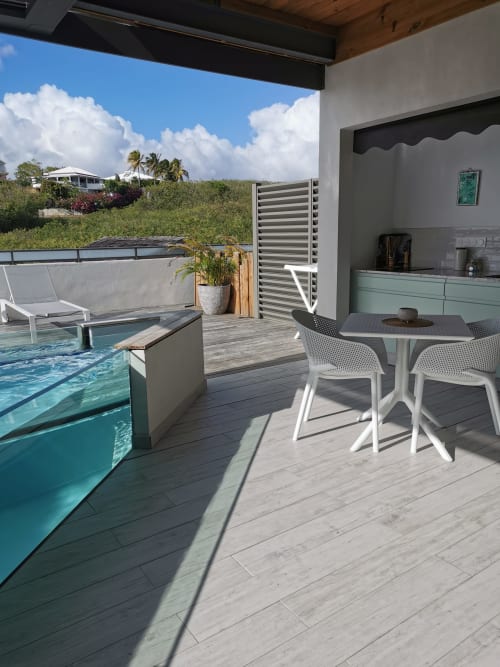 Terrasse tropicale à l'Habitation l'SEO avec piscine privée, coin repas et vue sur mer en Guadeloupe
