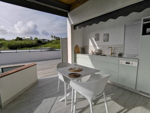 Cuisine extérieure moderne et espace de repas à l'Habitation I'SEO en Guadeloupe avec mobilier blanc, pergola et vue sur mer