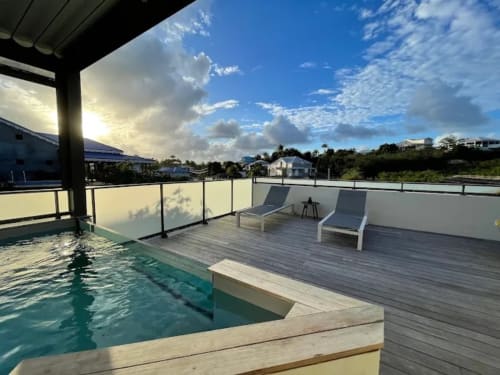 Terrasse piscine de l'Habitation l'SEO à Sainte-Anne avec transats, vue océan et paysage tropical