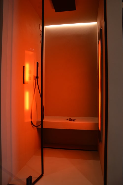 Bagno moderno con illuminazione ambientale arancione e cabina doccia in vetro a Villa Rosati, Sanzeno
