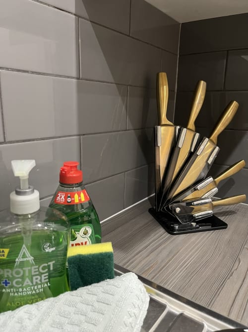 Kitchen counter at Empire Serviced Apartments Leicester with knife block, hand wash, and cleaning supplies