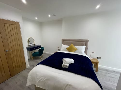 Modern one bedroom suite at Empire Serviced Apartments Leicester with queen bed, dressing table, and city view