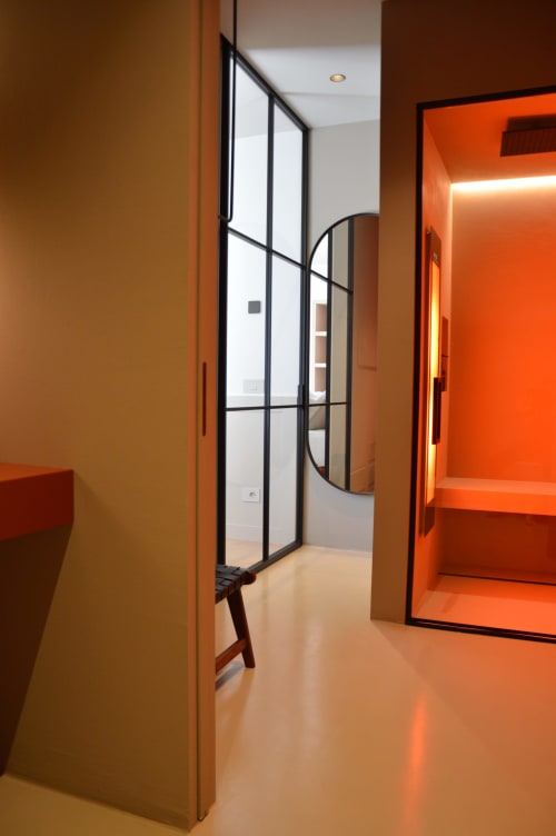 Corridoio moderno della Camera Resina di Villa Rosati con pareti in caldo arancione, porta in vetro con cornice nera e design minimalista
