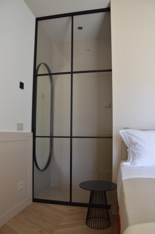 Bagno moderno con doccia con cornice nera e specchio circolare nero in Villa Rosati a Sanzeno
