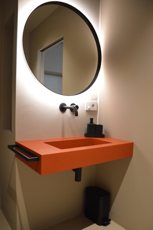 Lavabo moderno con bacino arancione vivace e specchio circolare retroilluminato a Villa Rosati, Sanzeno