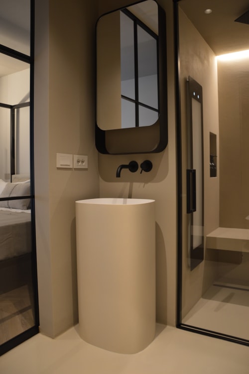 Bagno moderno di Villa Rosati con lavabo a colonna cilindrica, rubinetto a parete e specchio incorniciato a Sanzeno