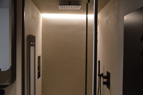 Bagno moderno a Villa Rosati a Sanzeno con doccia elegante, soffione pioggia e illuminazione d'ambiente