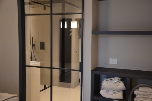 Bagno moderno con doccia in vetro dai telai neri a Villa Rosati, Sanzeno, con vani per asciugamani