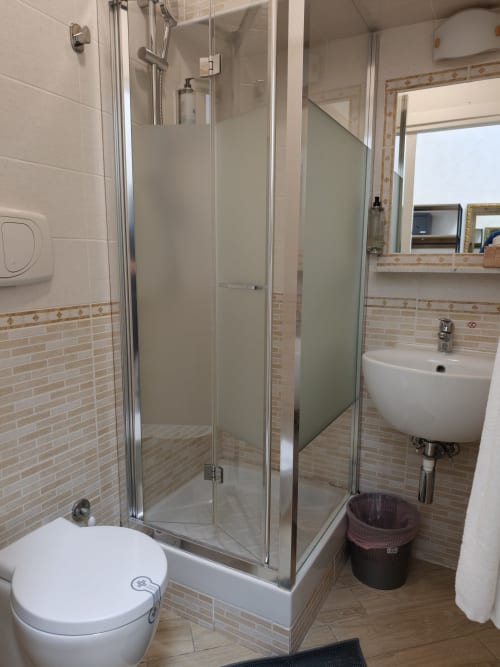 Bagno moderno della camera economica dell'Hotel Principe Amedeo con box doccia in vetro, water e lavandino