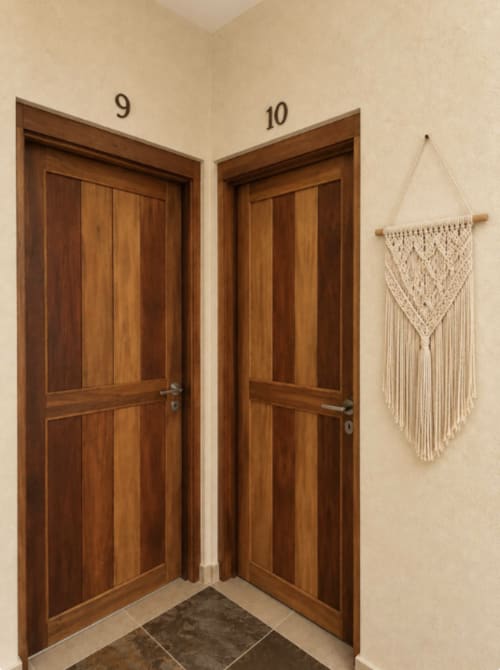 Entrada de la Suite 10 del Hotel Holbox Centro con puertas de madera y tapiz de macramé