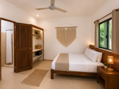 Dormitorio moderno en Hotel Holbox Centro en Holbox, México, con cama de madera, tapiz de macramé y jardín tropical