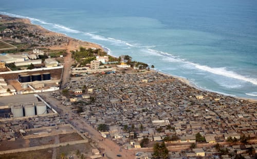 Vue aérienne de la propriété balnéaire Nomads Kodjoviakopé à Lomé, Togo avec vagues océaniques et quartiers adjacents