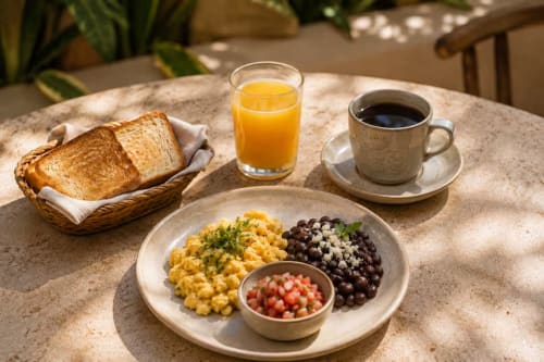 Desayuno en el Hotel Holbox Centro con pan tostado, maíz fresco, frutos rojos, tomates, jugo de naranja y café en Holbox