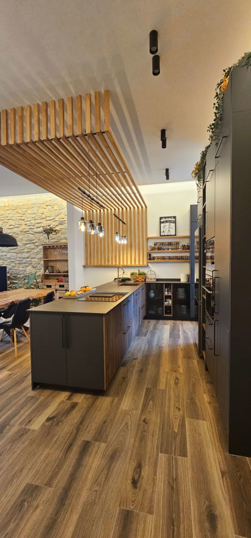 Cocina moderna del Hotel Izarbe en Burgos con techo de lamas de madera, barra isla y diseño contemporáneo