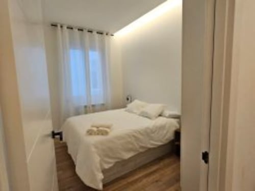 Habitación moderna del Hotel Izarbe en Burgos con ropa de cama blanca, decoración minimalista y luz natural desde las ventanas