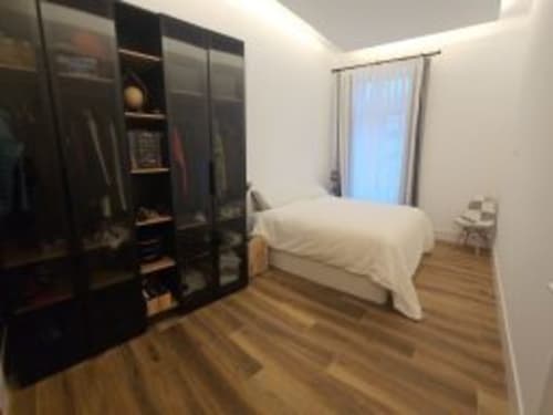 Moderno dormitorio del Hotel Izarbe en Burgos con cama, armario oscuro y gran ventana