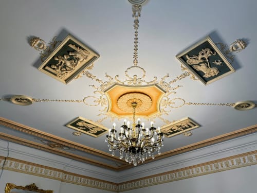 Verzierter Kassettenhimmel mit goldgerahmten Feldern, Kristallleuchter und dekorativen Stuckleisten im Domaine de Bize in Mirepoix