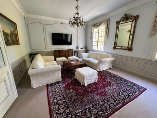 Elegantes formales Wohnzimmer mit cremefarbenen Sofas, verziertem Kronleuchter und dekorativem Teppich in der Mirepoix Manor Suite