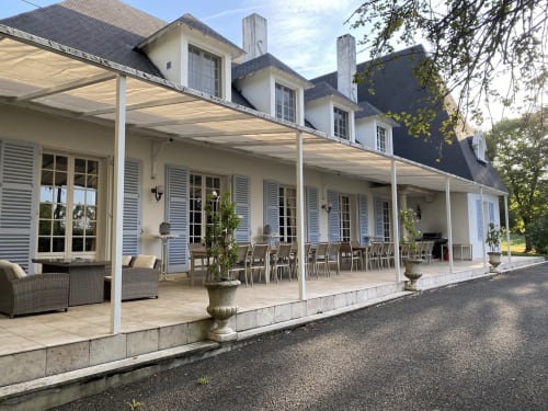 Elegante Herrenhaus-Terrasse mit Pergola, Essbereich und Fensterläden auf Domaine de Bize in Mirepoix, Ariège.